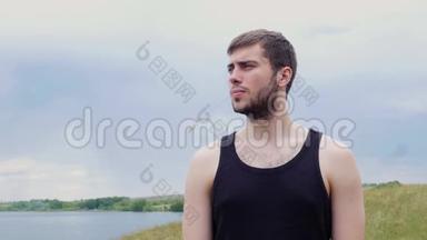 那个年轻人正向远处望着一个湖和一座山。 年轻人望着远处的湖